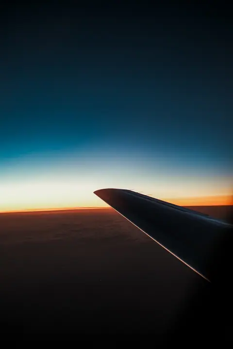 Airplane wing against a dusk sky